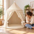 Beige castle tent beside a seated adult for scale