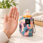 Pink warmer wrapped around a capped bottle beside an adult palm for scale