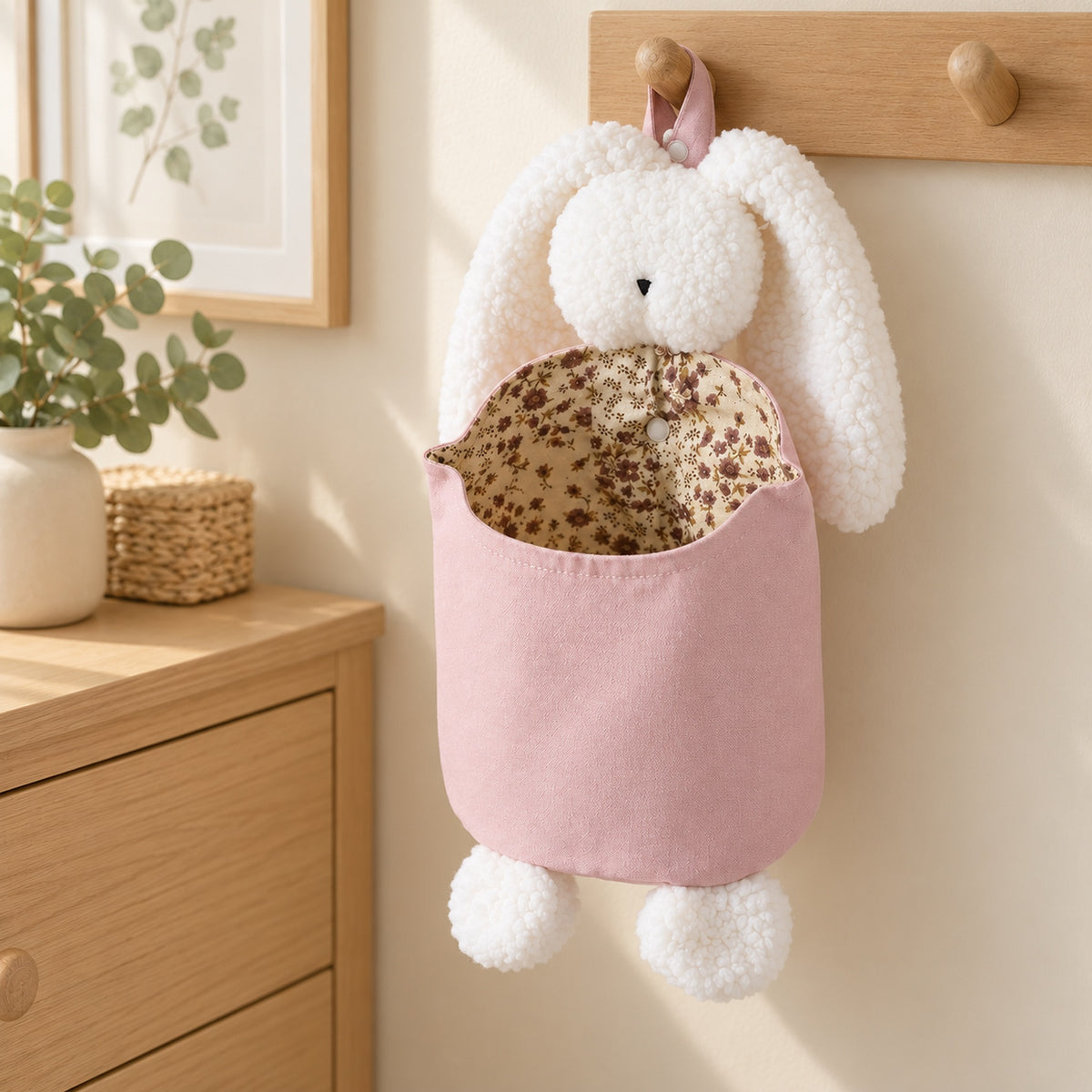 Empty Pink and White Bunny organizer on a wall hook beside a dresser