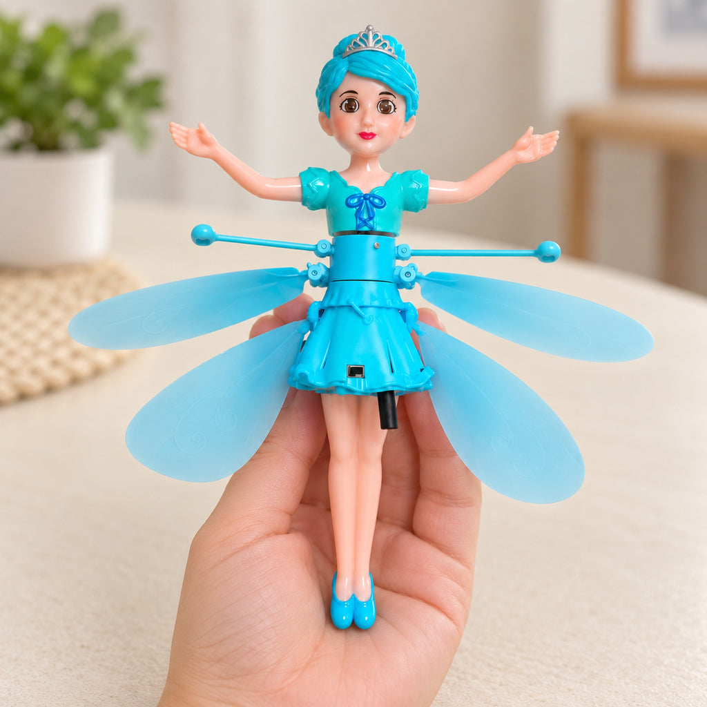 Switched-off blue flying fairy doll cradled in an adult hand for scale