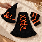 Adult arranging the pointed witch hat beside the cloak and socks on a floor photo mat