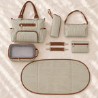 Khaki tote, four matching pouches, oval changing pad and pair of stroller straps laid out together